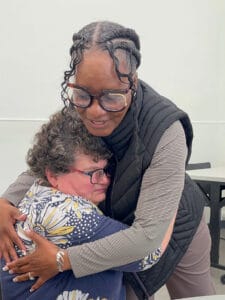 Bancroft's Velma Green embraces a female individual at a day program