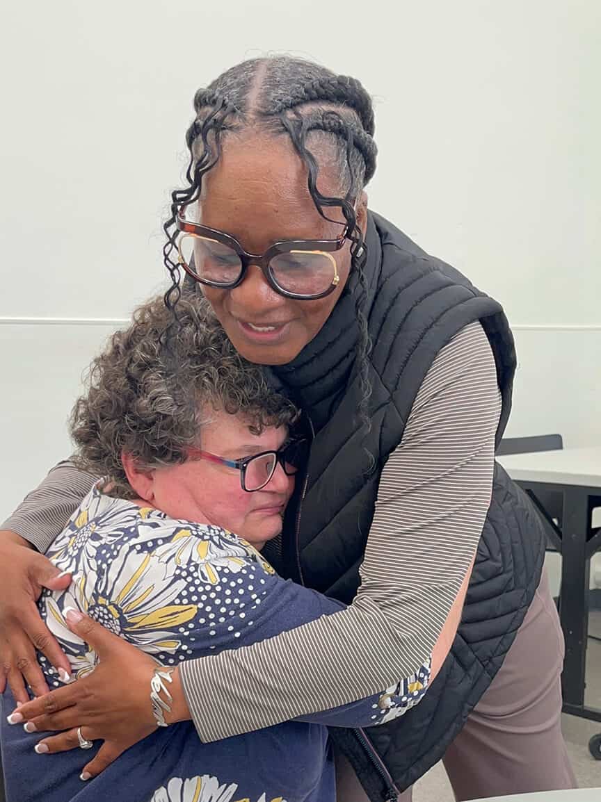 Bancroft's Velma Green embraces a female individual at a day program